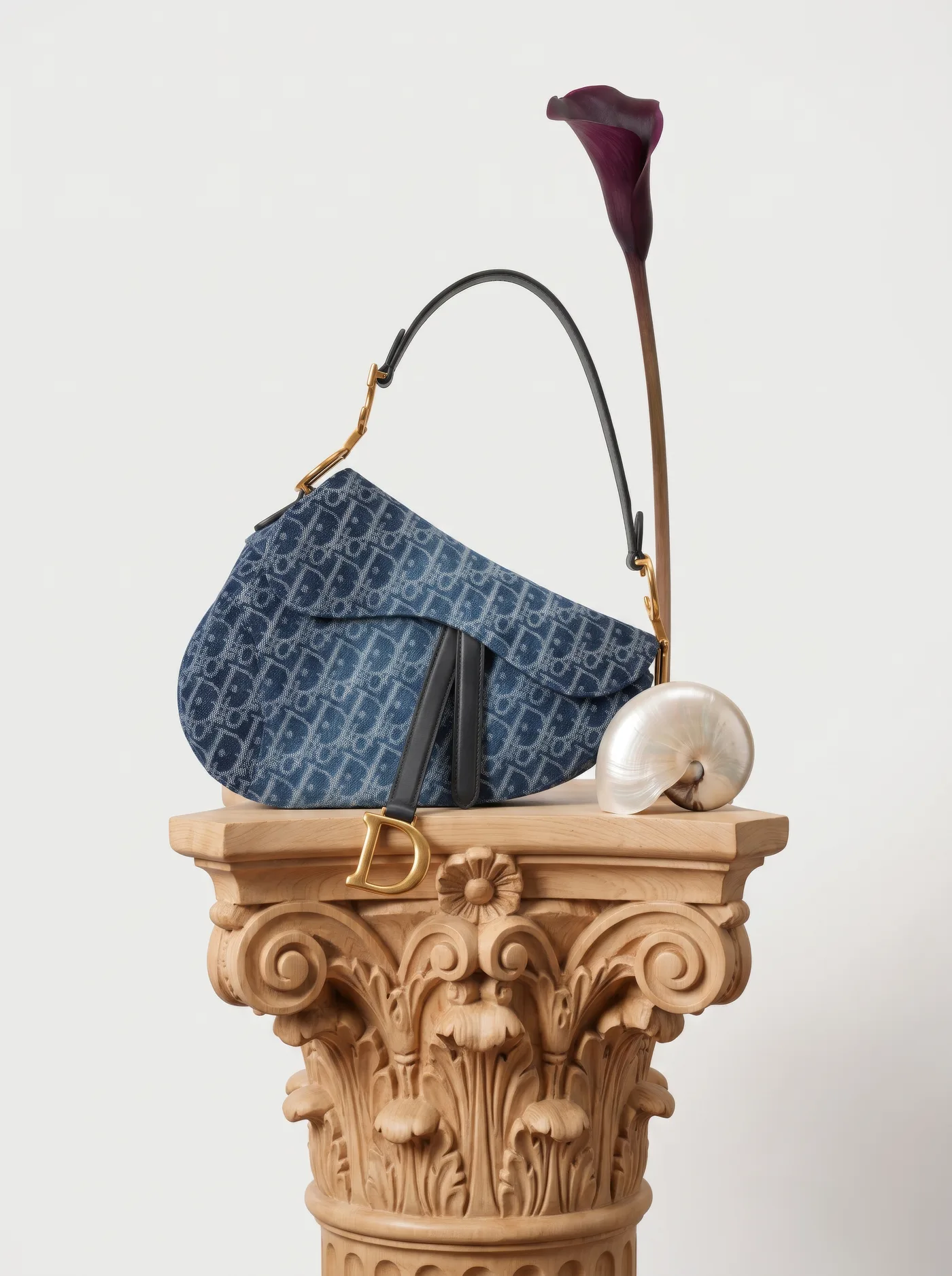 Curved saddle-shaped bag on a carved Corinthian capital with a calla lily