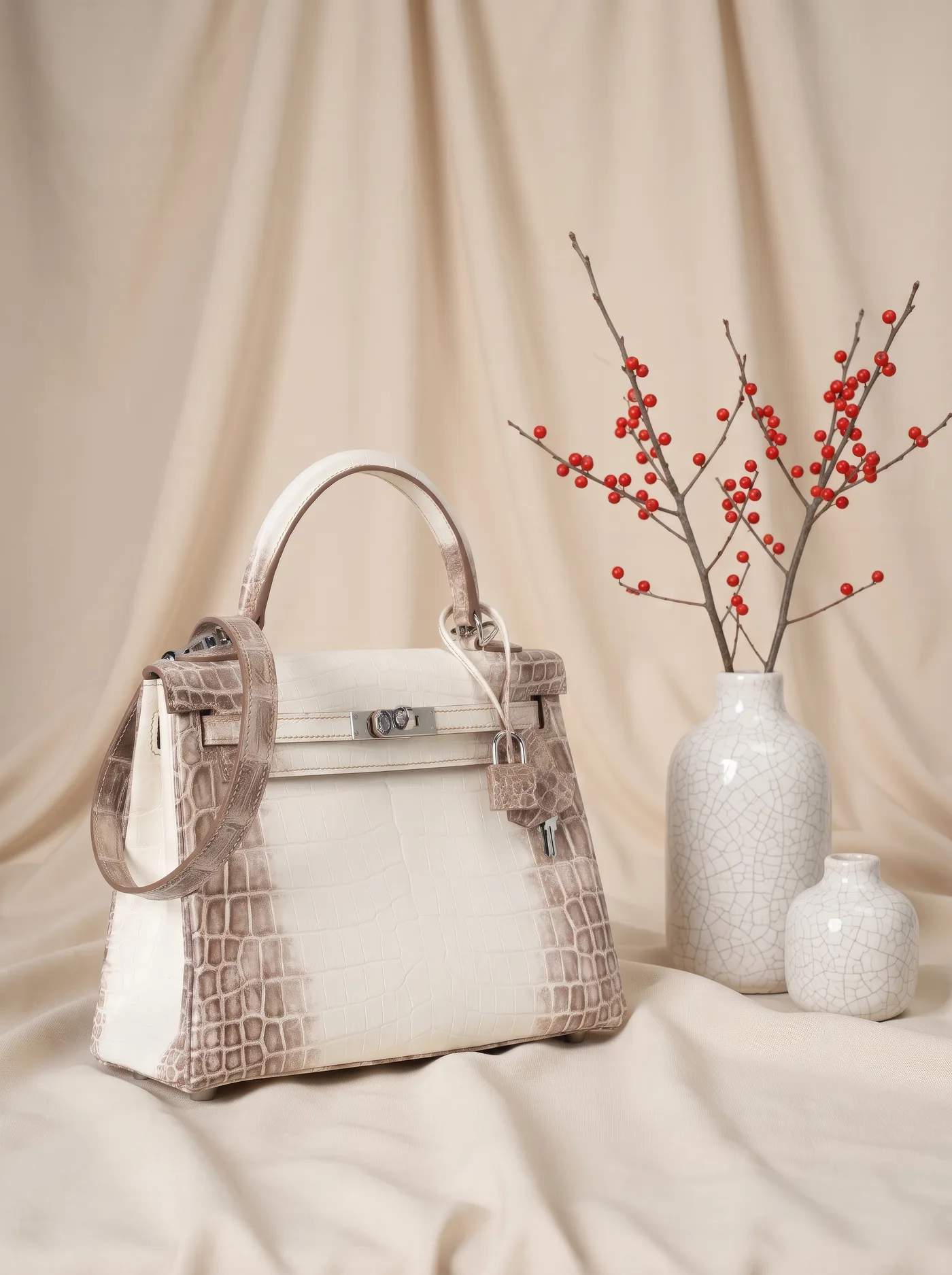 Structured top-handle bag beside crackle-glazed porcelain vases and winterberries